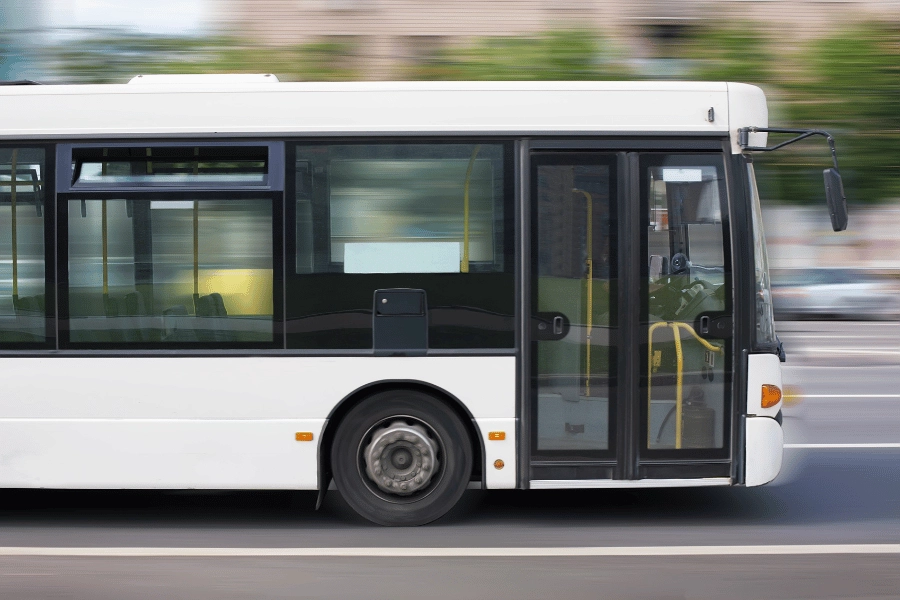 white bus on the go driving on the street